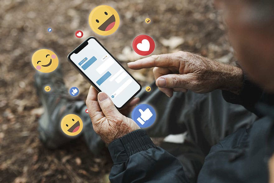 Person holding mobile phone with emojis surrounding the phone and illustration of texts on the phone