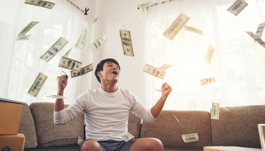Happy man clenching fists while money is flying in the air