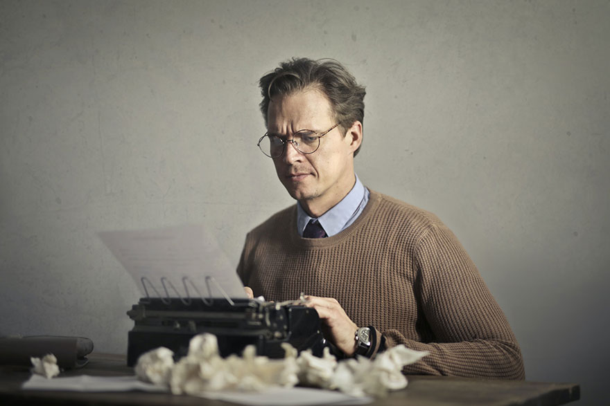 man using a typewriter but is having a writer's block
