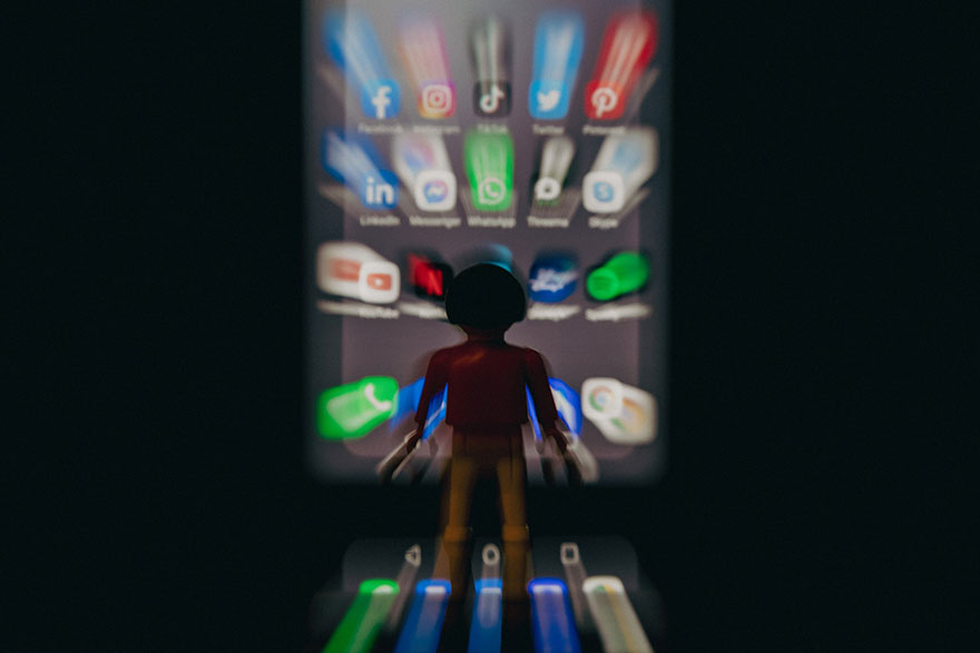 a toy standing in front of a mobile phone