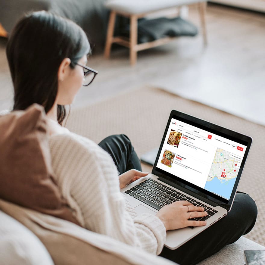 Image of a person sitting on a laptop visiting Yelp