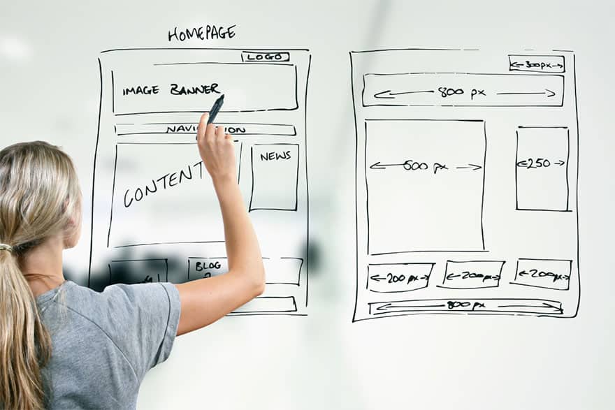 Young designer drawing a website wireframe on a whiteboard