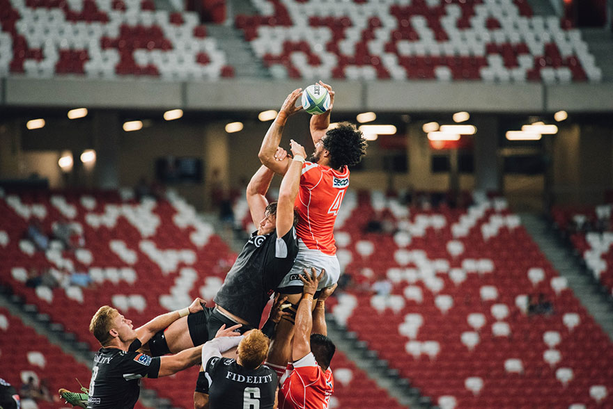 competitor catches rugby ball while being lifted by teammate