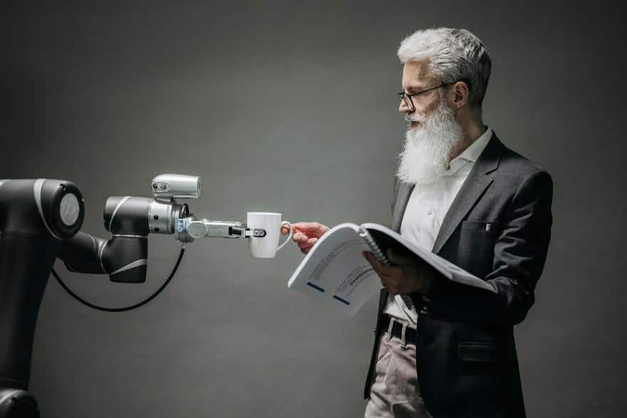 Man receiving a cup of coffee from a robotic arm