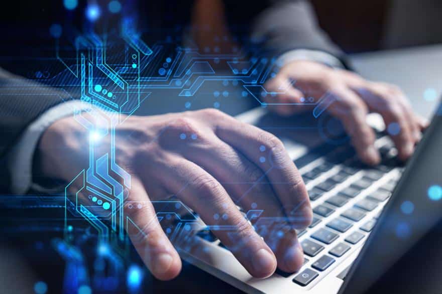 Man in business suit sitting at desk working on laptop with technology illustrations showing